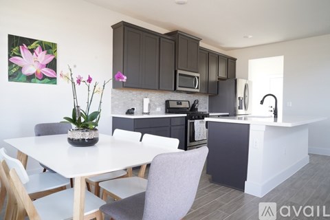 A kitchen with a table and chairs in front of it.