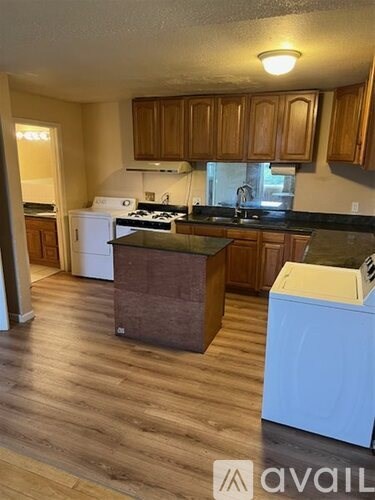 A kitchen with wooden cabinets and a white dishwasher.