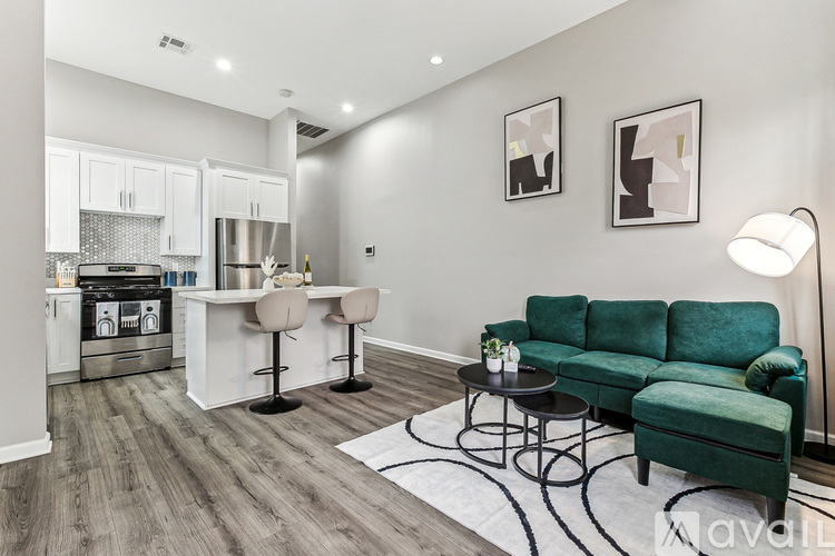 A modern kitchen with a green sofa and a bar area.