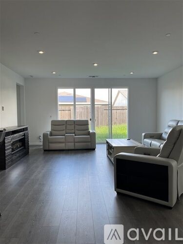A living room with a white couch and a television.