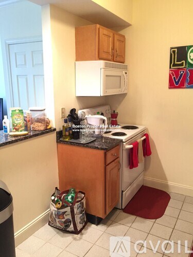 A kitchen with a white microwave and a bag of chips on the counter.