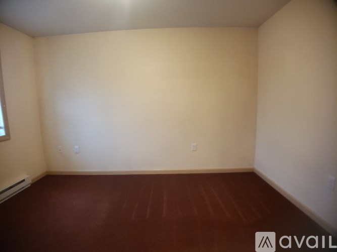 A room with a brown floor and beige walls.
