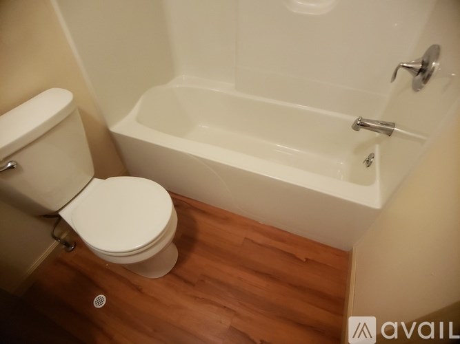 A white toilet sits next to a bathtub in a bathroom.