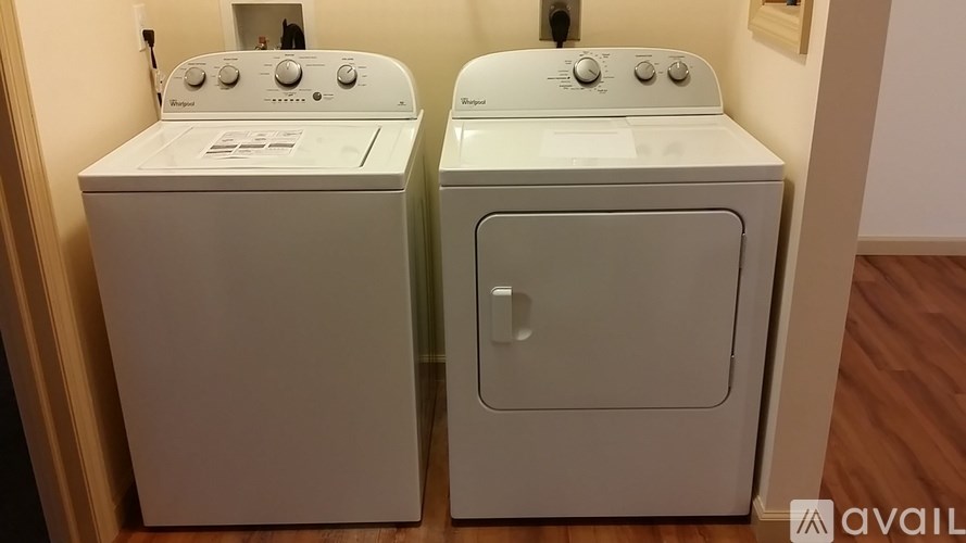 Two white front loading washing machines in a laundry room.