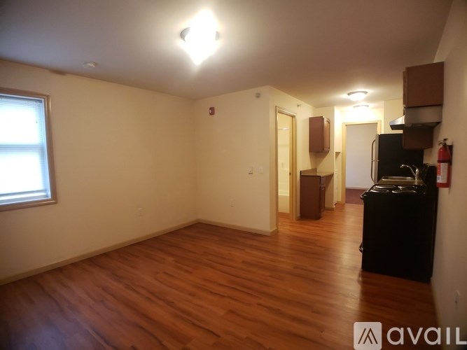 A room with wooden floors and a window on the left side.