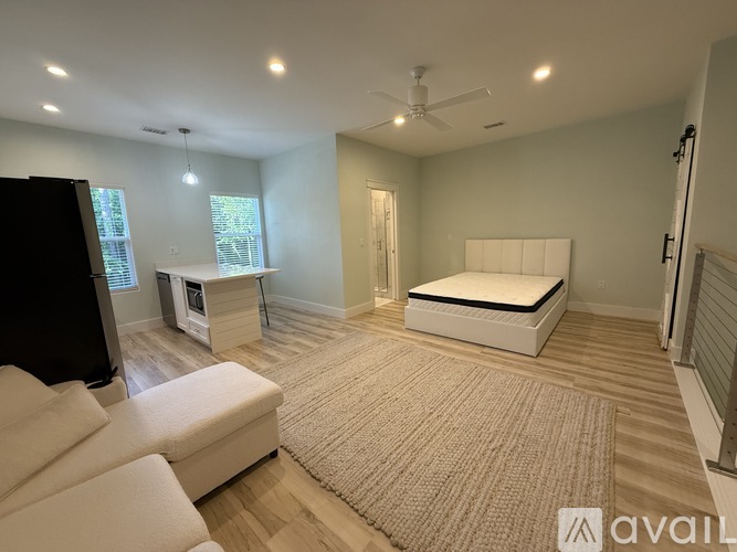 A bedroom with a bed, a couch, and a television.