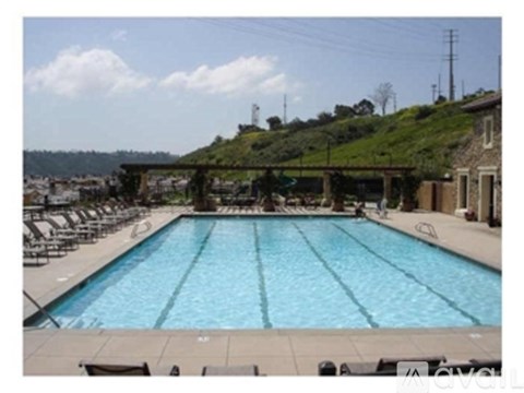 A large outdoor swimming pool surrounded by lounge chairs.