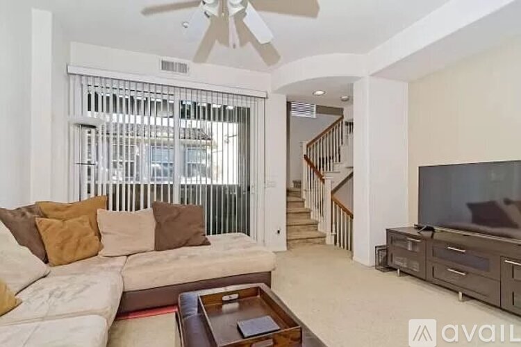 A living room with a couch, a coffee table, and a television.