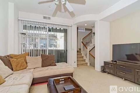 A living room with a couch, a coffee table, and a television.