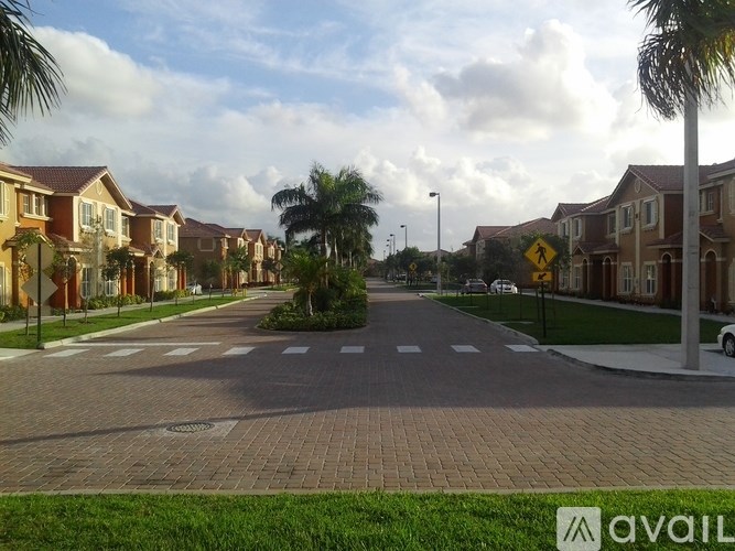 A street view of a residential area with houses on both sides and a pedestrian crossing in the middle.