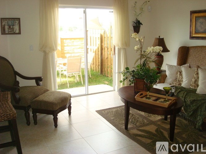 A living room with a chair, a sofa, a table, and a window.
