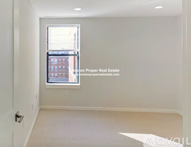 A room with a window showing a view of a building outside.