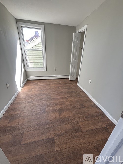 A room with wooden flooring and a window.