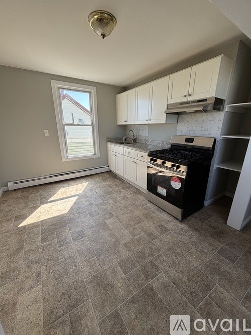 A kitchen with a tile floor and a window.