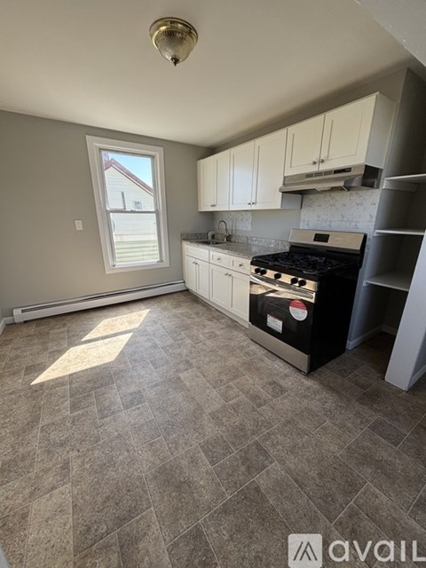 A kitchen with a tile floor and a window.