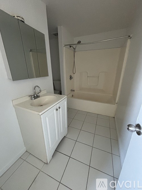 A white bathroom with a sink and a bathtub.