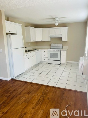 A kitchen with white appliances and cabinets.