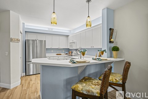 A kitchen with a table and chairs.