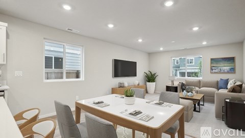 A modern living room with a dining table and chairs.