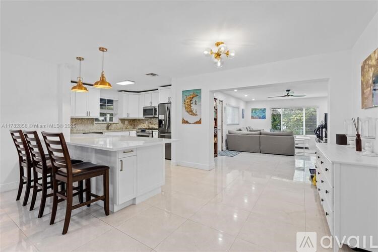 A kitchen with white cabinets and a marble countertop.