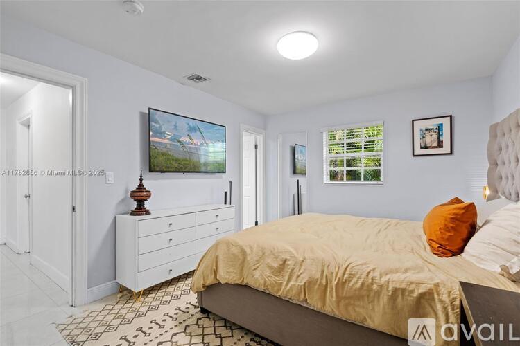 A bedroom with a bed, dresser, and television.