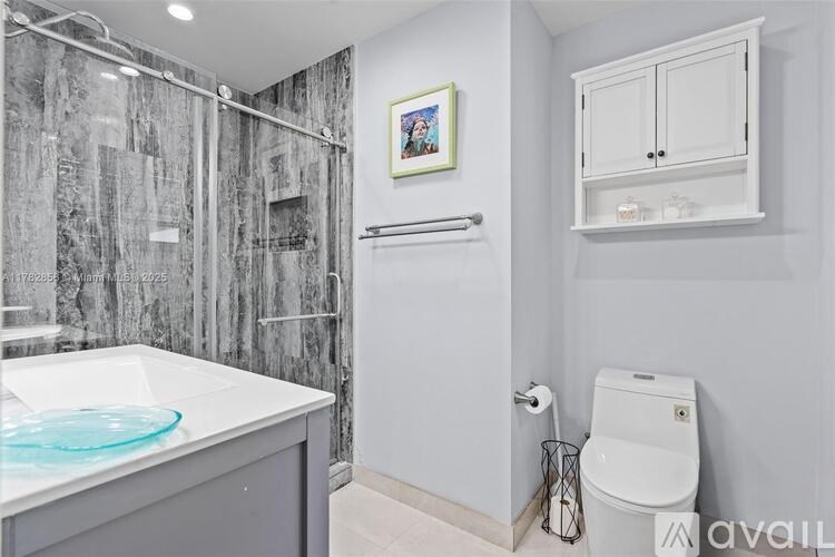 A bathroom with a toilet, sink, and shower.