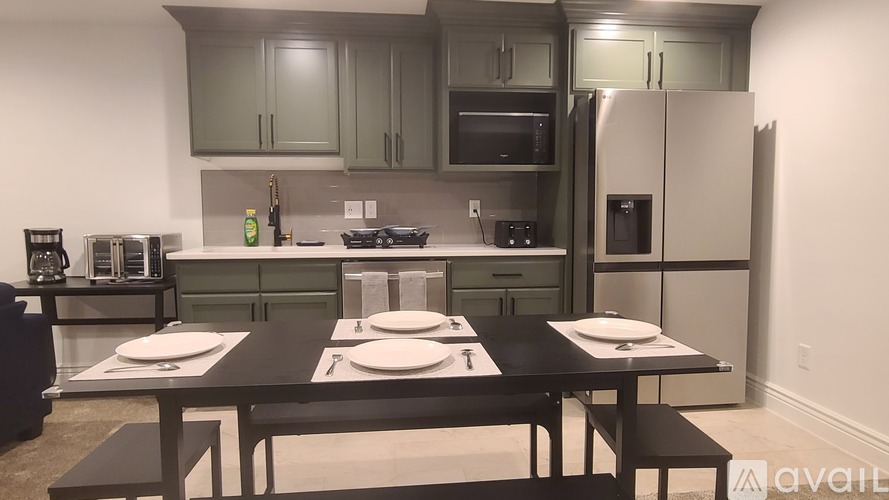 A kitchen with a table set for two in front of it.