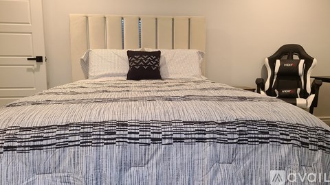 A bed with a white headboard and a blue and white striped comforter.