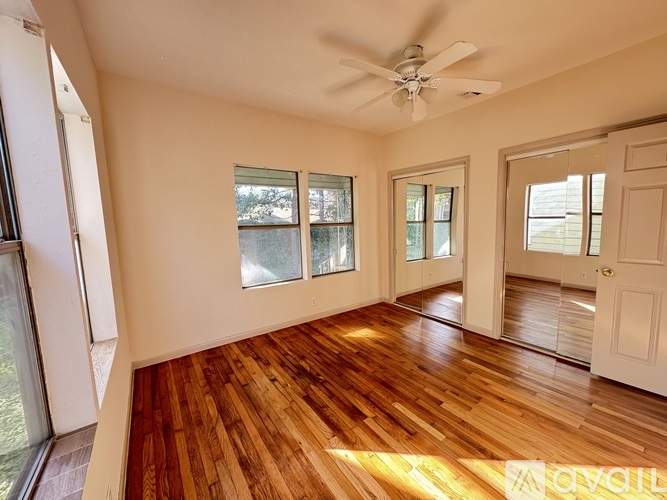 A room with wooden floors and a ceiling fan.