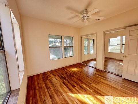 A room with wooden floors and a ceiling fan.