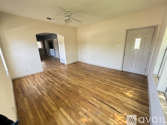 A room with wooden flooring and a ceiling fan.