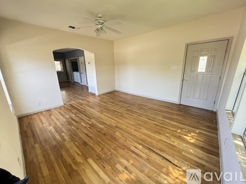 A room with wooden flooring and a ceiling fan.