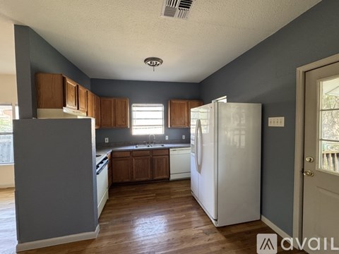 A kitchen with a white refrigerator and wooden cabinets.