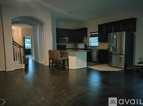A kitchen with a refrigerator, sink, and a dining table with chairs.