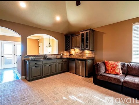 A kitchen with a sink and a couch.