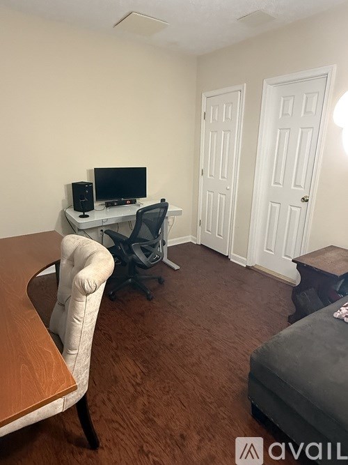 A room with a desk, chair, and a couch.