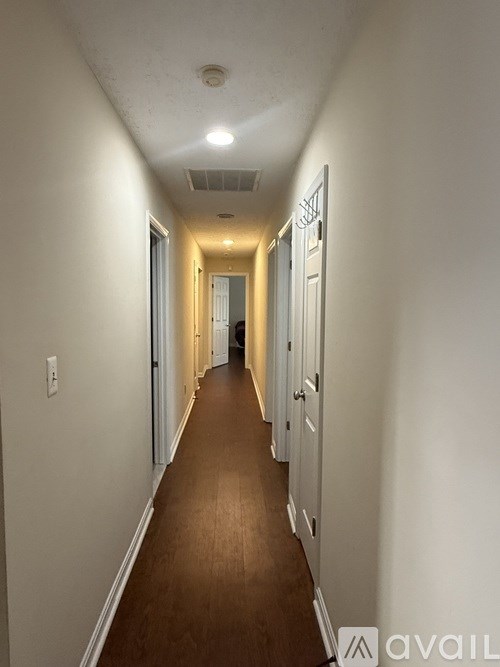 A long hallway with doors on both sides and a light on the ceiling.