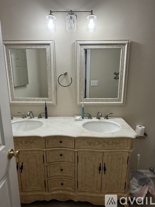 A bathroom with a vanity and two mirrors.