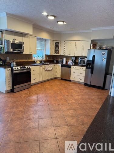 A kitchen with tile flooring and a refrigerator.