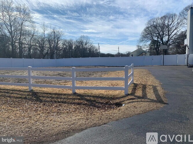 A white fence in a field with a sign that says "available".