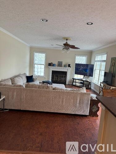 A living room with a couch, a fireplace, and a television.