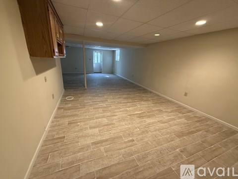 A spacious room with a tiled floor and a doorway leading to another room.