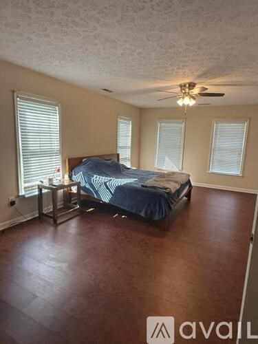 A bedroom with a bed, dresser, and window.