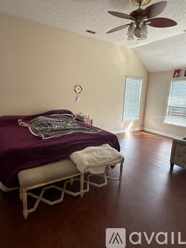 A bedroom with a bed and a chair.