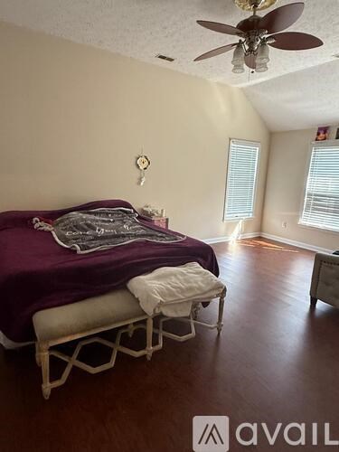 A bedroom with a bed and a chair.