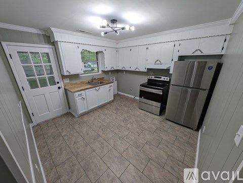 A kitchen with white cabinets and a tile floor.