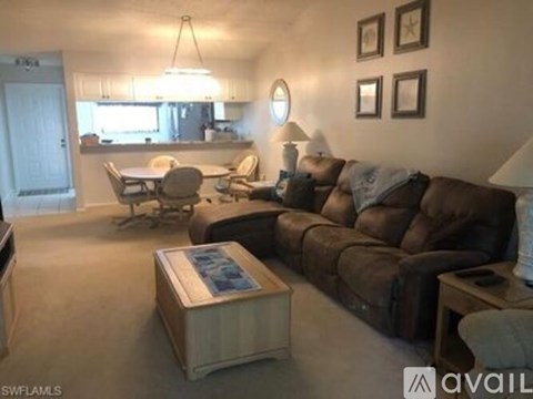 A living room with a brown couch and a coffee table.