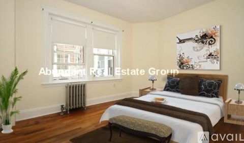 A bedroom with a large bed and a painting on the wall.