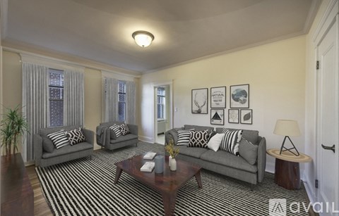 A living room with grey couches and a striped rug.