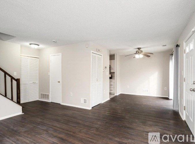 A spacious room with wooden floors and white walls.